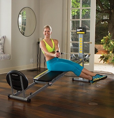 a woman uses the total gym fit